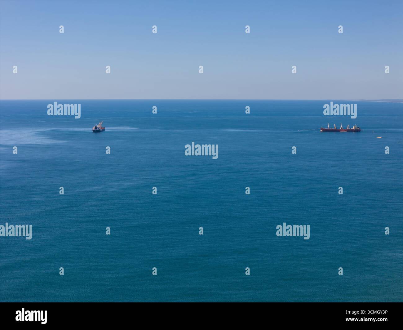 Frachtschiff auf blauem Meer Hintergrund Drohnenansicht Stockfoto