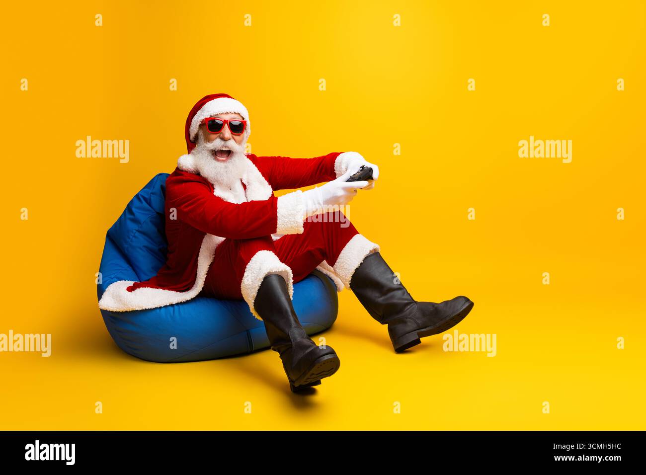 Charismatischer Weihnachtsmann Entspannen und Spielen in einem funky modernen Ambiente Stockfoto