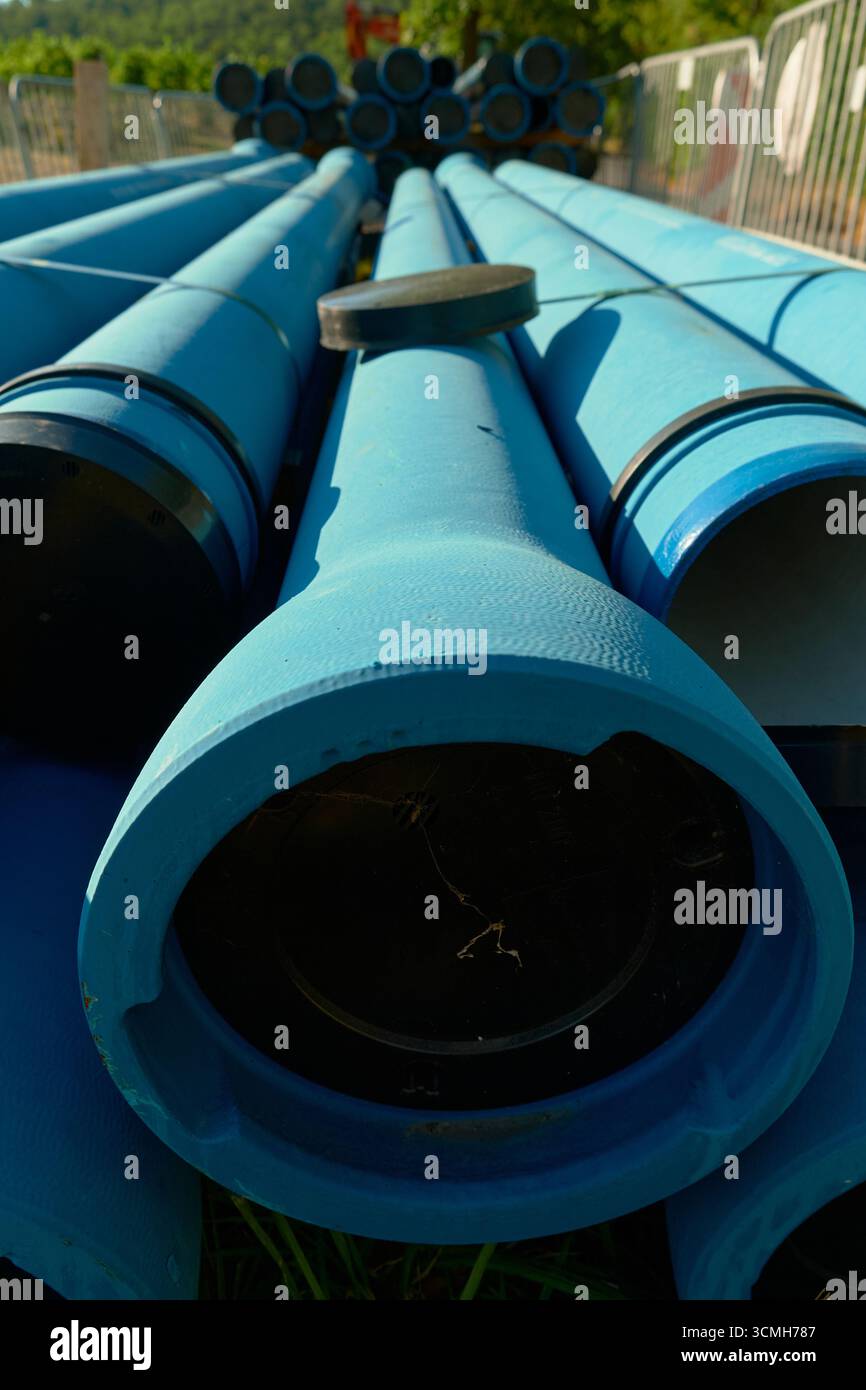 Vertikales Foto blauer technischer Rohre. Klare, detaillierte Ansicht, die industrielle Infrastruktur, Ausrüstung und mechanische Komponenten in einem hellen Licht hervorhebt Stockfoto