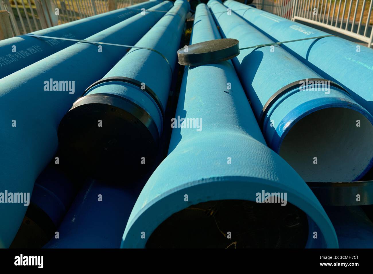 Vertikales Foto blauer Industrierohre. Detailansicht mit technischen Infrastrukturen, Maschinenkomponenten und Baugeräten Stockfoto