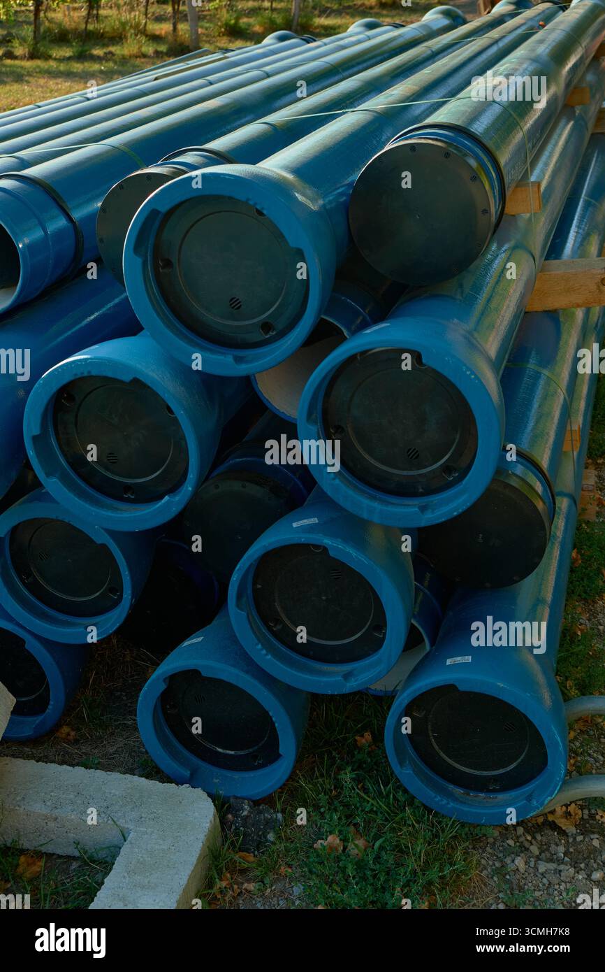 Vertikales Foto blauer Industrierohre und -Rohre mit sichtbaren Verbindungsverbindungen. Detaillierte Ansicht zeigt technische Infrastruktur und Bauelemente Stockfoto