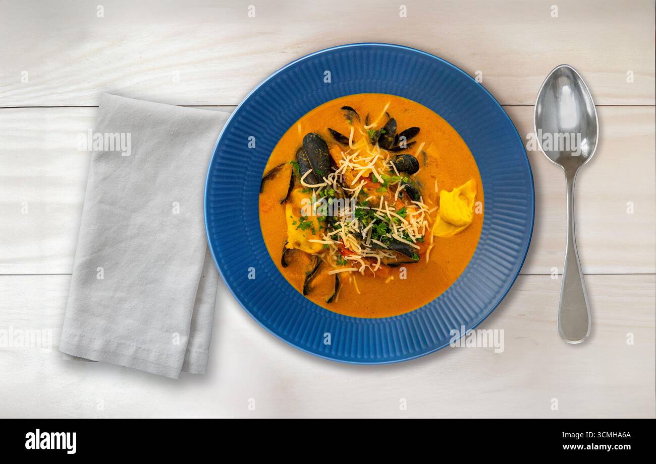 Tisch fertig mit Bouillabaisse-Suppe. Blick von oben auf köstliche Fischsuppe mit Fischfilet Muscheln, anderen Schalentieren und Gemüse. Stockfoto