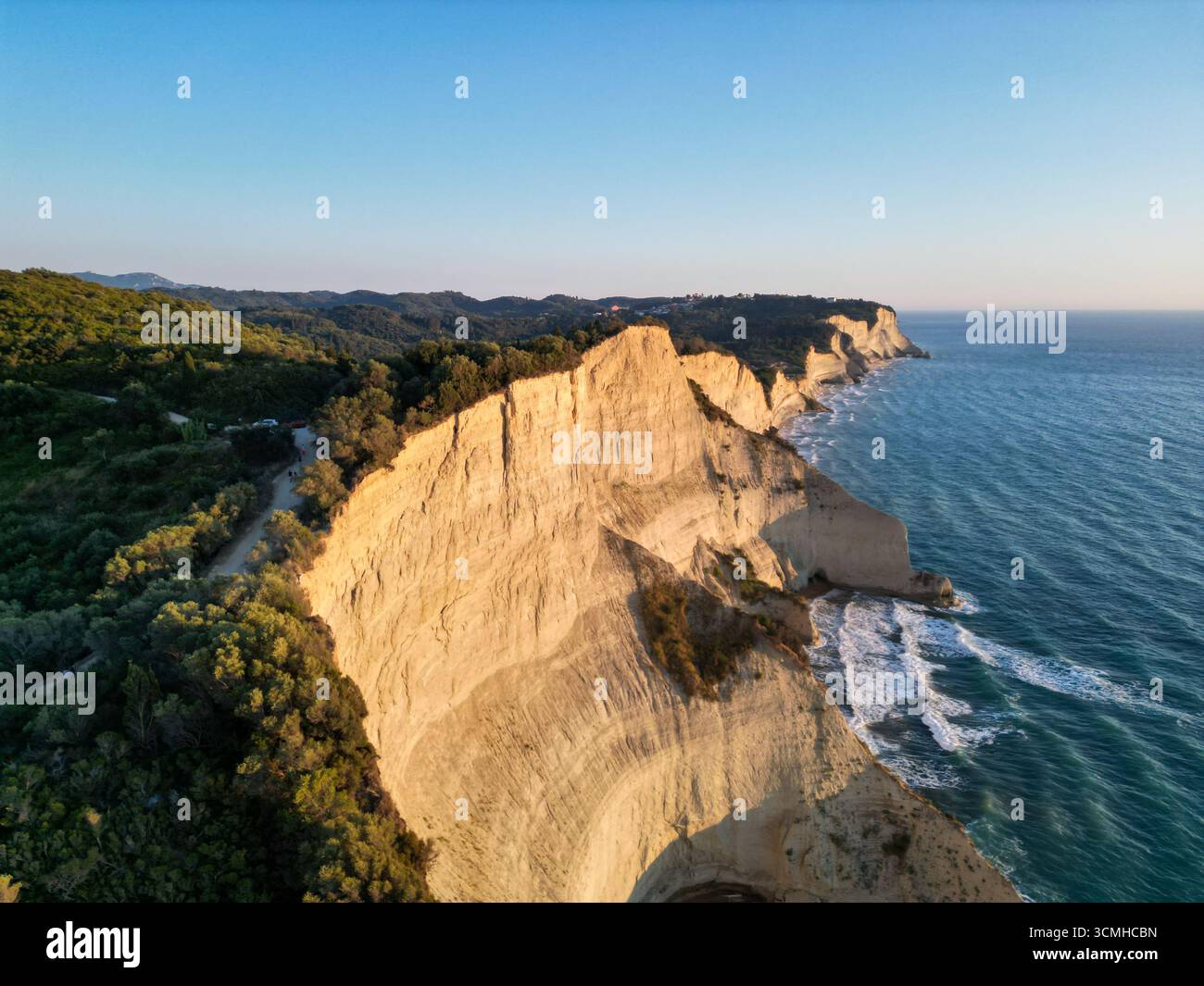 Ein traumhafter, rosafarbener Blick aus der Vogelperspektive auf die ikonischen Tonklippen von Kap Drastis bei Sonnenuntergang auf Korfu Island, Griechenland Stockfoto