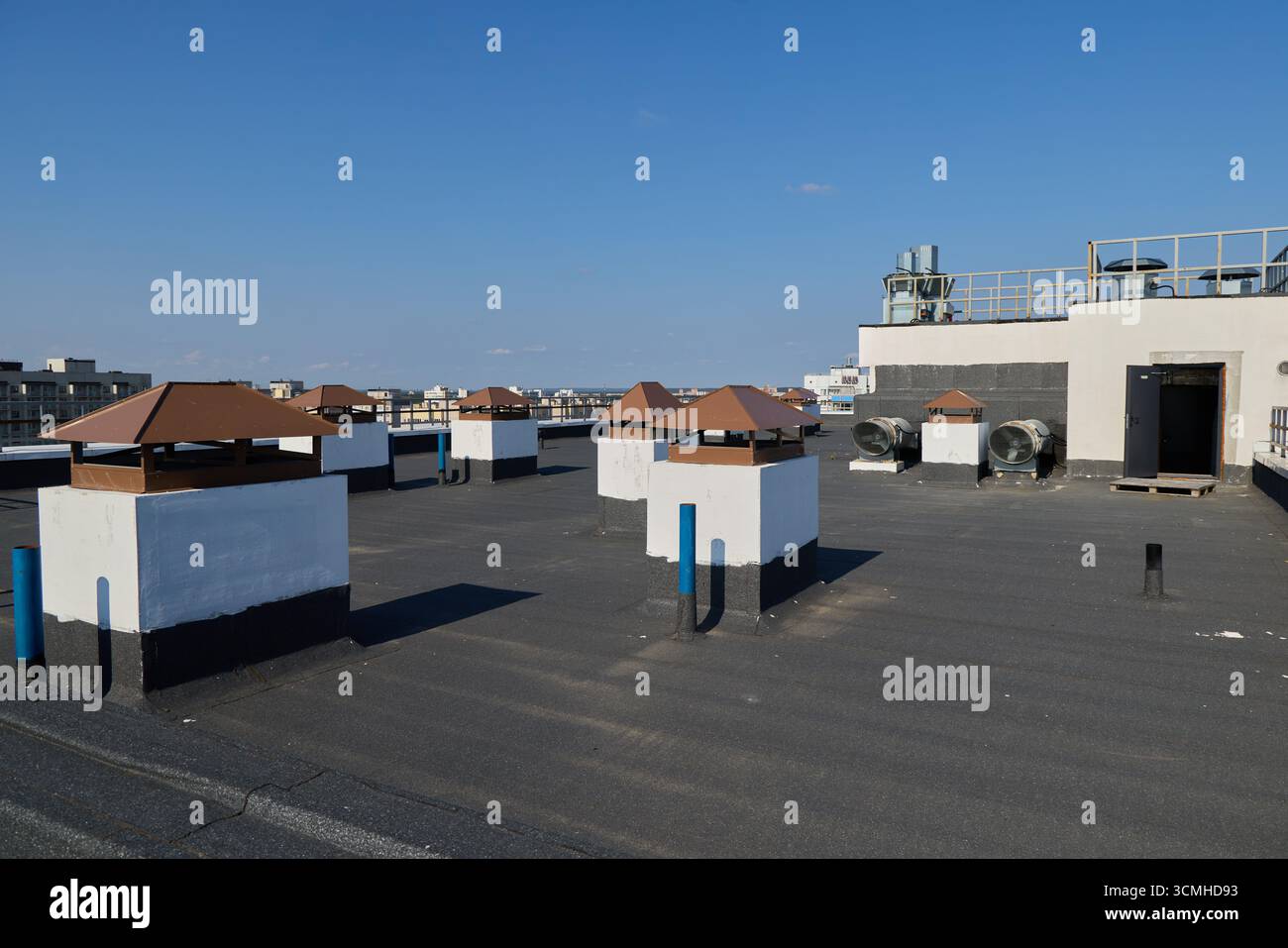 Das pulsierende Dach der Stadt bietet Lüftungsstrukturen vor dem Hintergrund eines klaren blauen Himmels Stockfoto