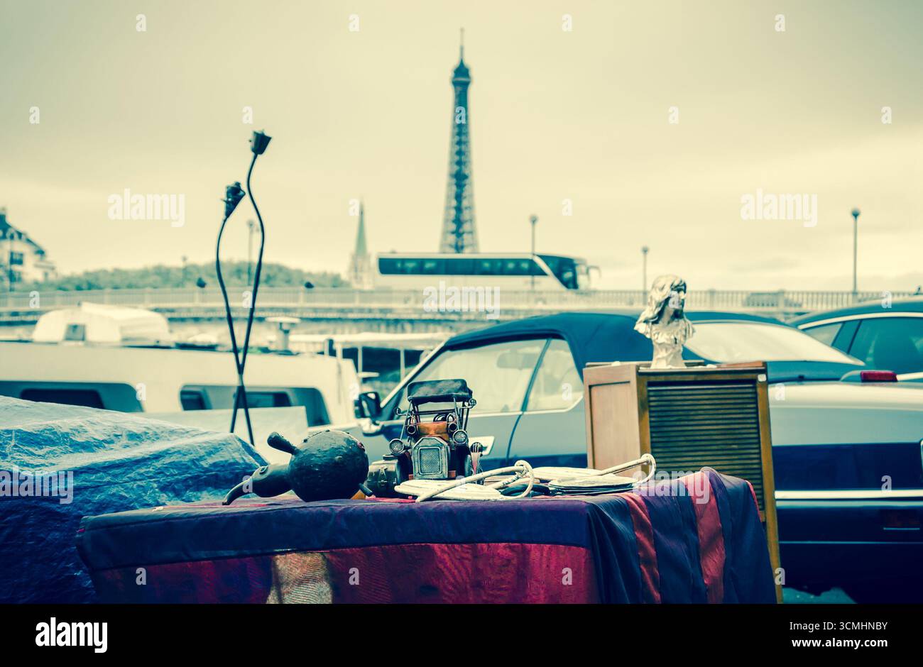 Flohmarkt in Paris, Frankreich. Oldtimer-Modell und anderes Zeug auf einem Stand mit Blick auf die seine-Ufer und den Eiffelturm. Retro-Foto. Stockfoto