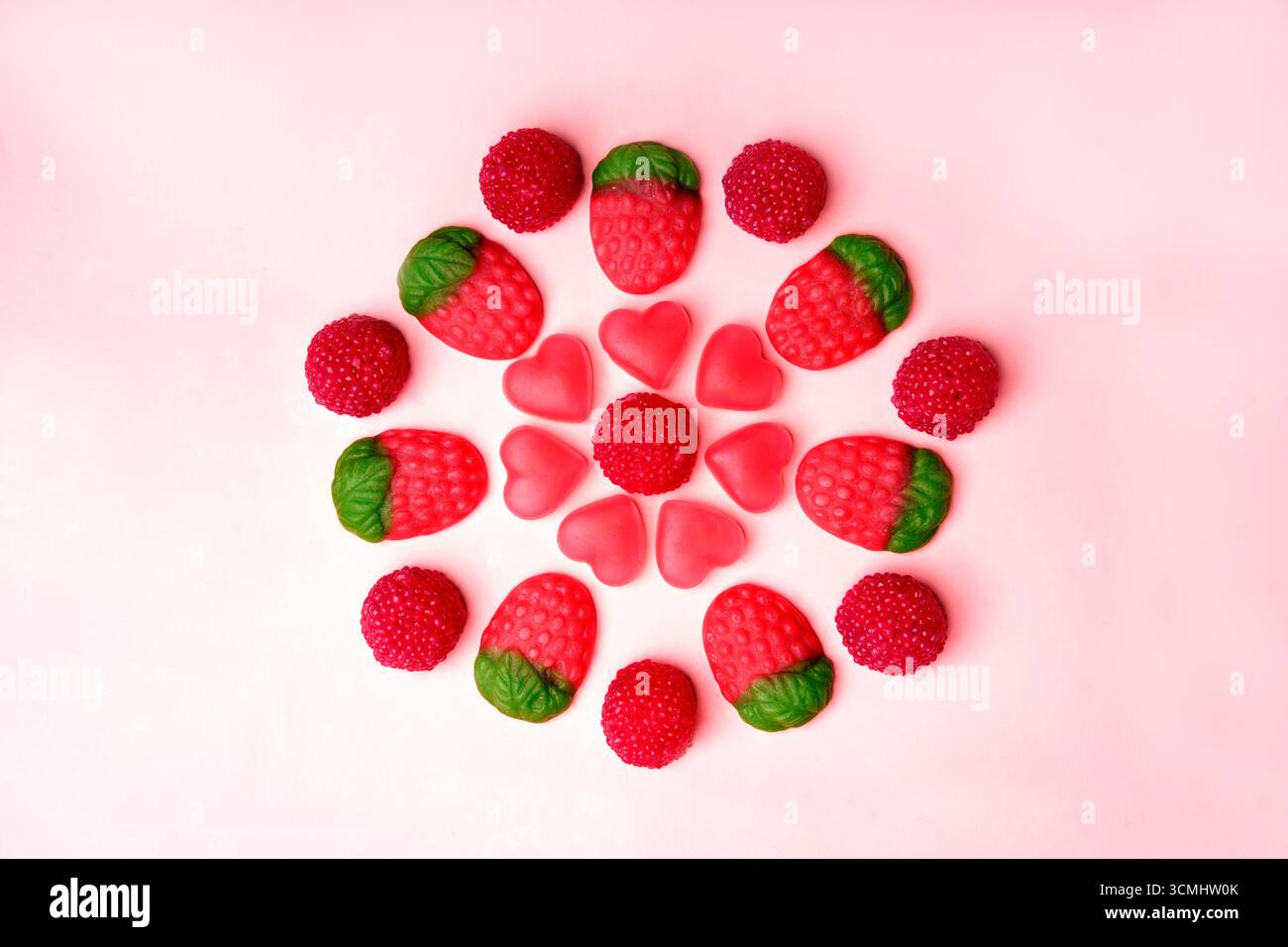 Bunte gummiartige Bonbons in Blumenform schaffen eine fröhliche und verspielte Szene Stockfoto