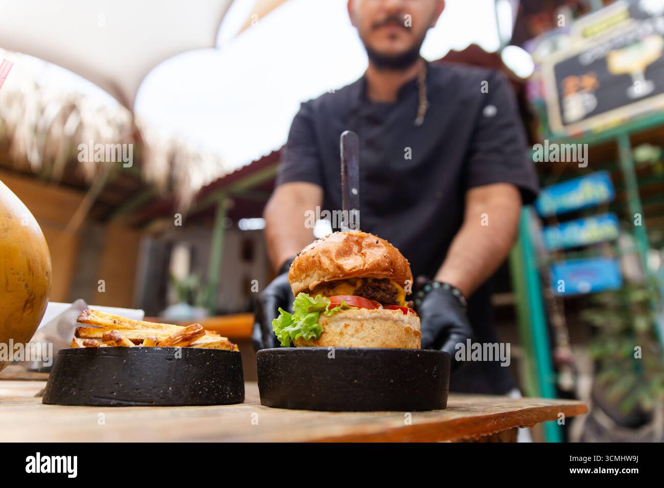 Der Koch präsentiert einen köstlichen Burger Stockfoto