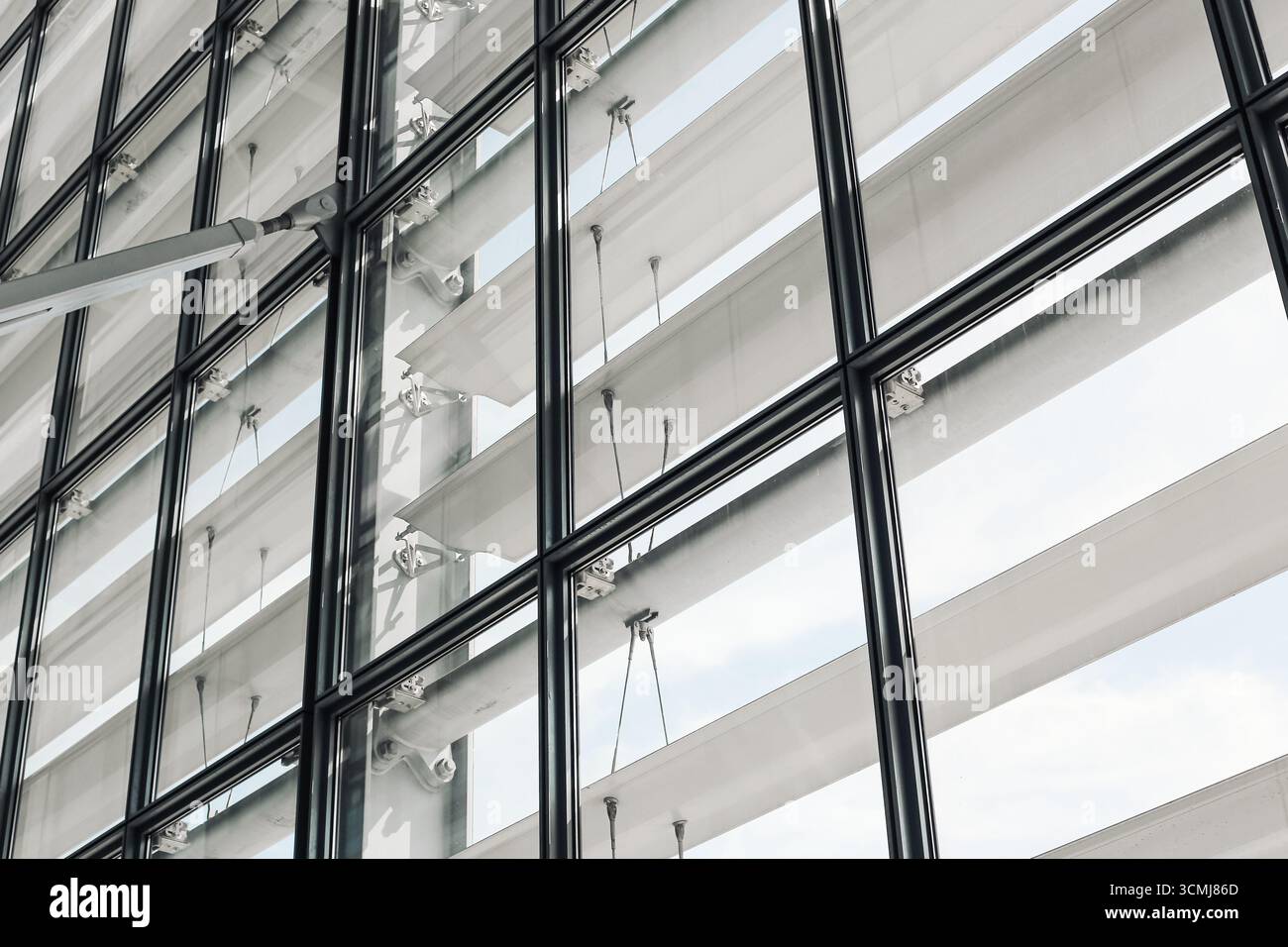 Moderne Glasfassade. Zeitgenössische Architektur mit Reflexion. Außenansicht des städtischen Büros mit Fenstern. Minimalistisches geometrisches Design. Stockfoto
