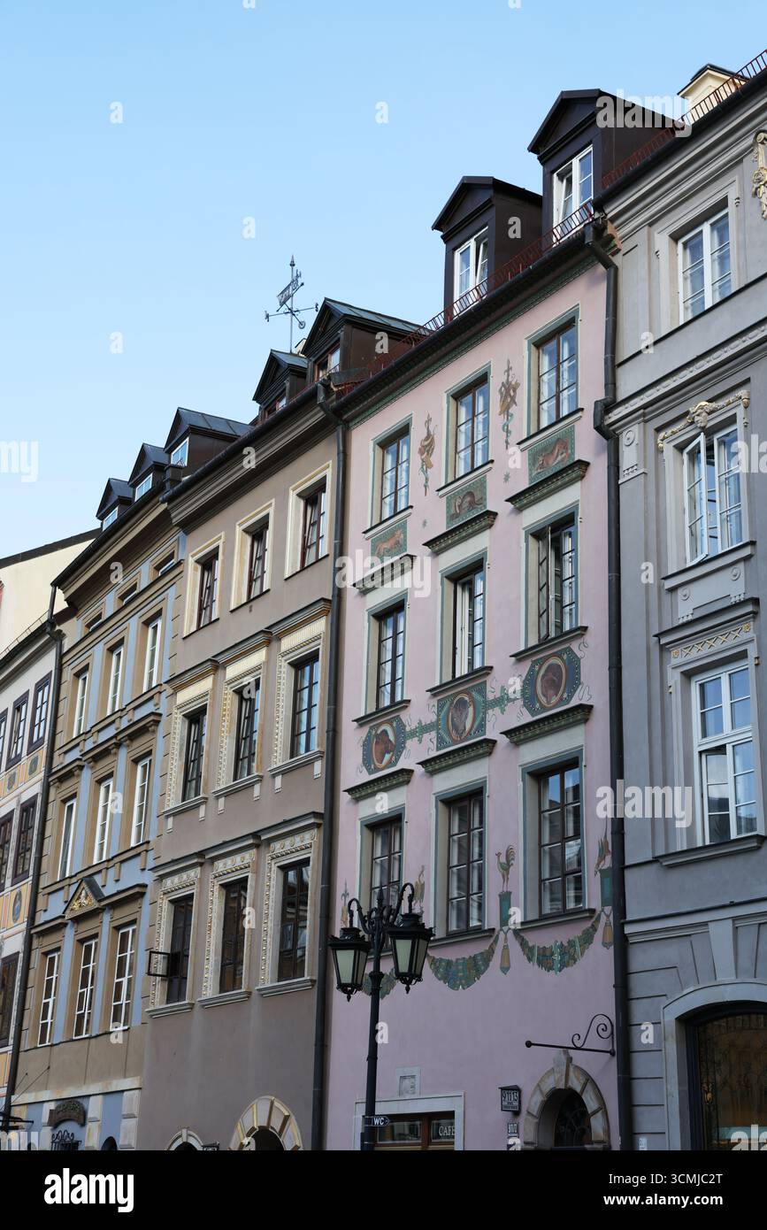 Bezaubernde pastellfarbene Fassaden und historische Fenster in der Warschauer Altstadt unter klarem blauen Himmel Stockfoto