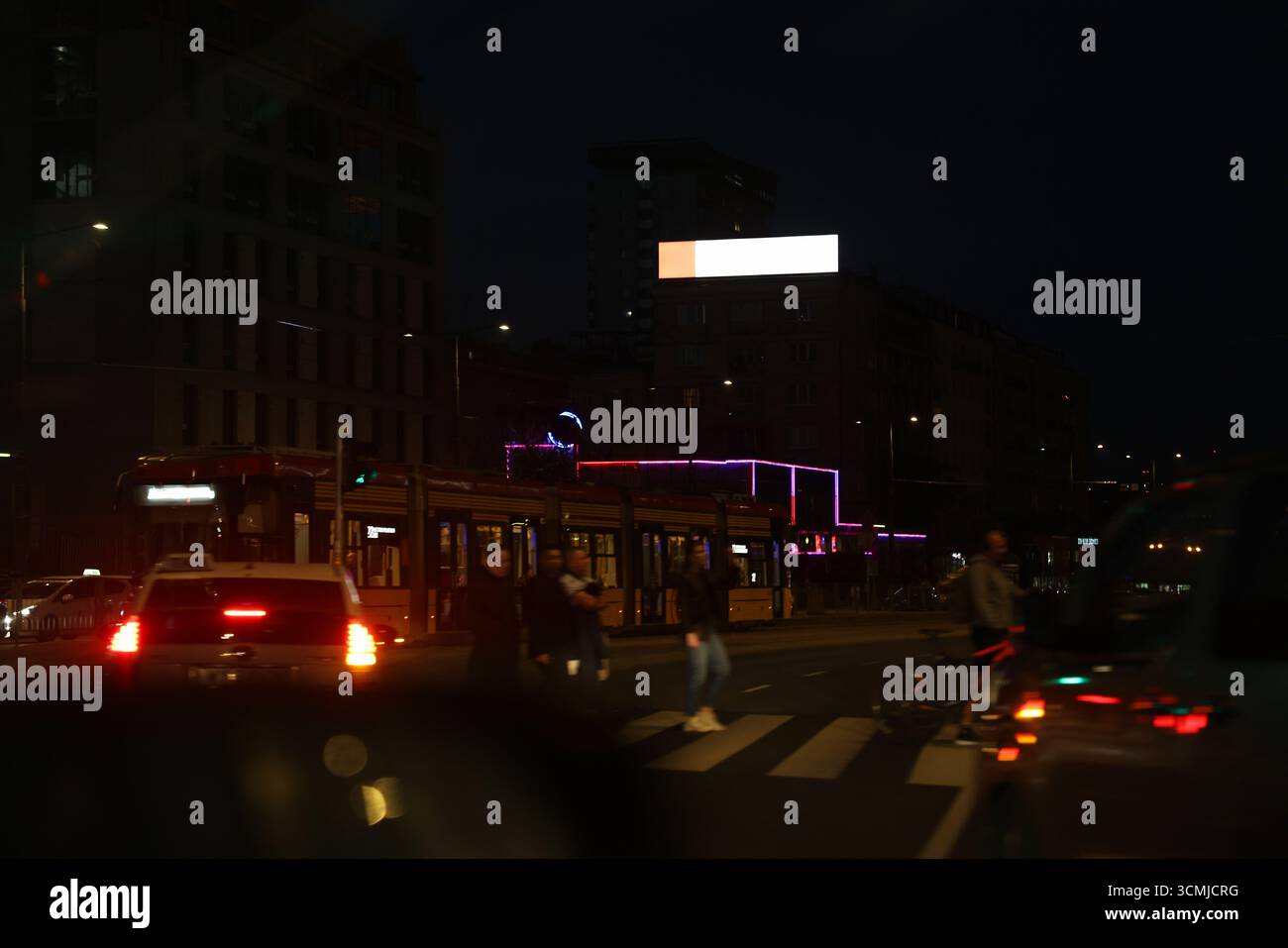 Warschauer öffentlicher Platz in der Nacht mit leuchtenden Schildern und Menschen in Bewegung Stockfoto