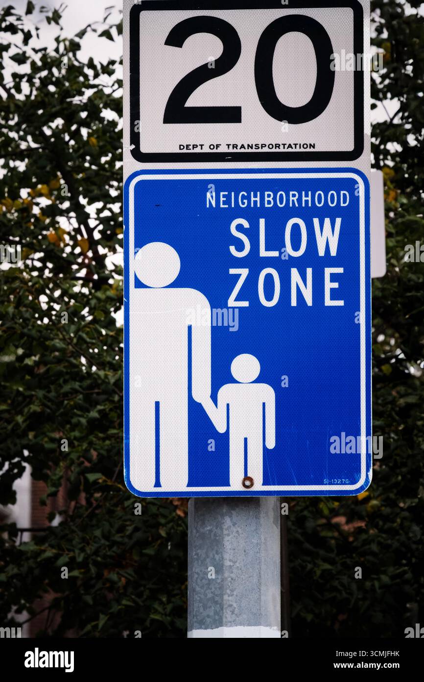 Ein Schild für eine langsame Zone in Sunnyside, Queens, New York, mit einer Geschwindigkeitsbegrenzung von 20 km/h, die Kindern hilft. Stockfoto