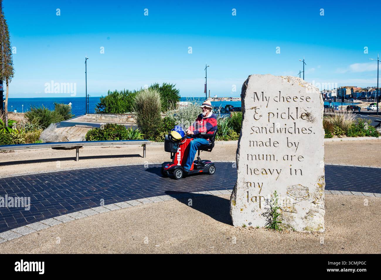 Mobilitätsroller vorbei an der Skulptur Standing Stones in Margate, Kent, Großbritannien Stockfoto