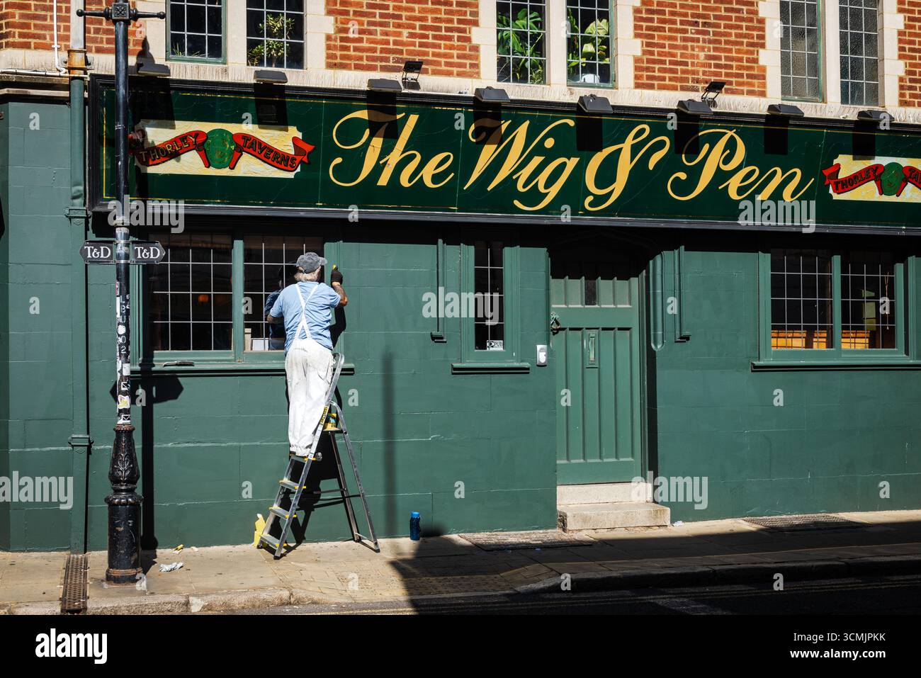 Maler arbeitet außerhalb des WIG & Pen Pubs, Margate, Kent Stockfoto