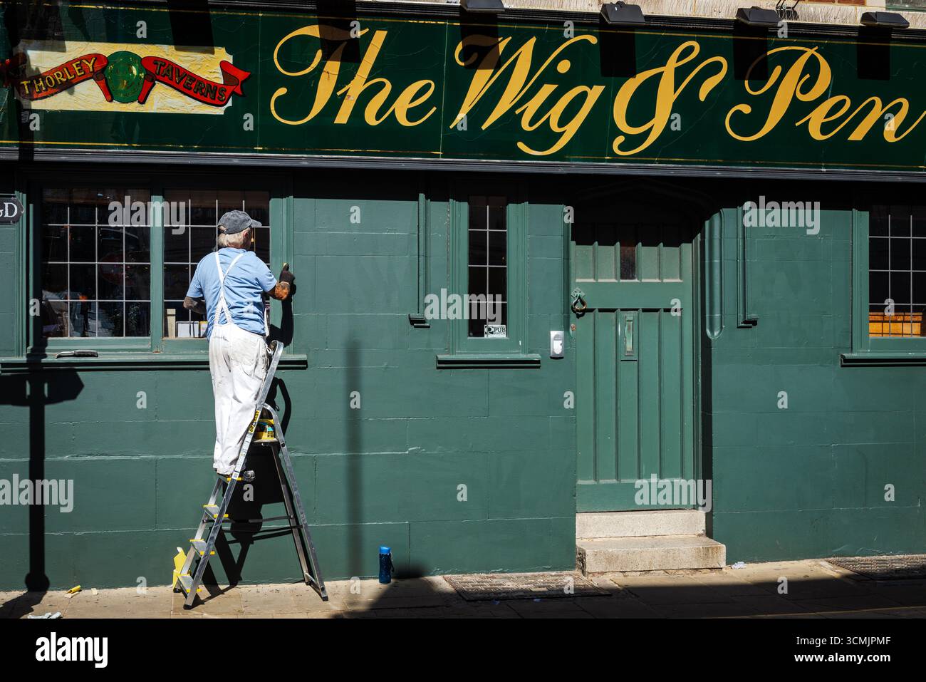 Maler arbeitet außerhalb des WIG & Pen Pubs, Margate, Kent Stockfoto