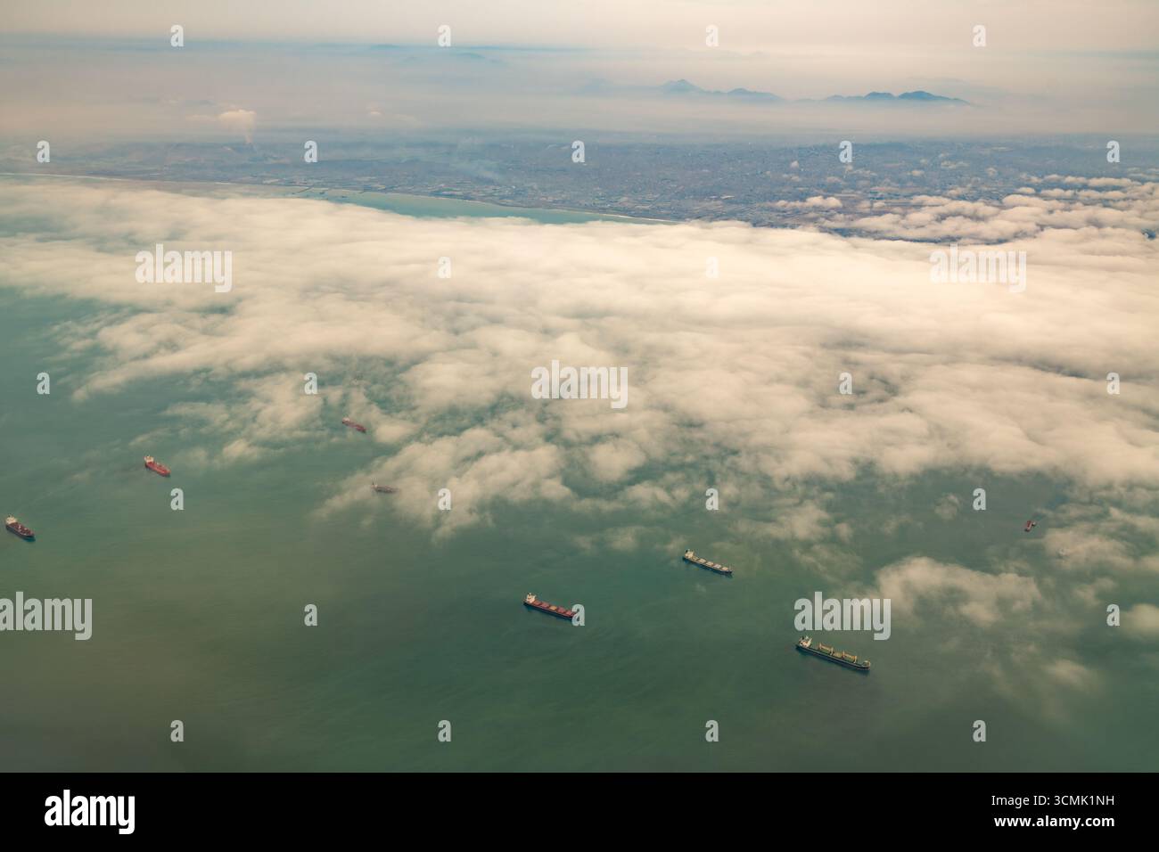Ein Blick auf das Meer in der Nähe des Hafens Callao, Peru, mit Frachtschiffen, die unter einem bewölkten Himmel andocken. Stockfoto