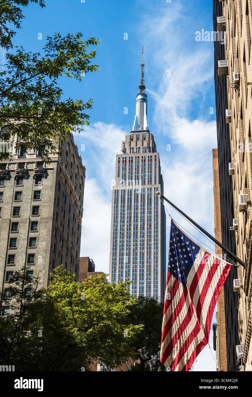 Das ikonische Empire State Building ist mit einer amerikanischen Flagge auf der East 34th Street, New York City, USA 2025, zu sehen Stockfoto