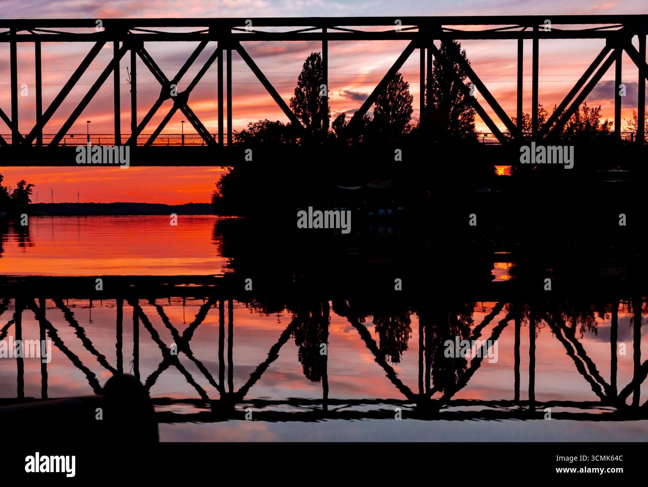 Eisenbahnbrücke in Caputh, Brandenburg, Silhouette bei Sonnenuntergang über Schwielowsee Stockfoto