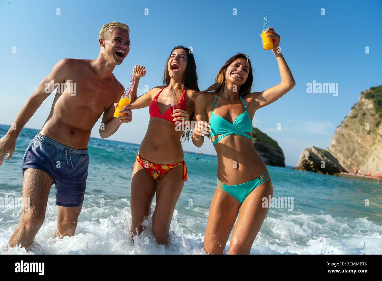 Gruppe von jungen Reisenden, die einen sicheren Strandurlaub genießen und die Freude an geschütztem Reisen hervorheben Stockfoto