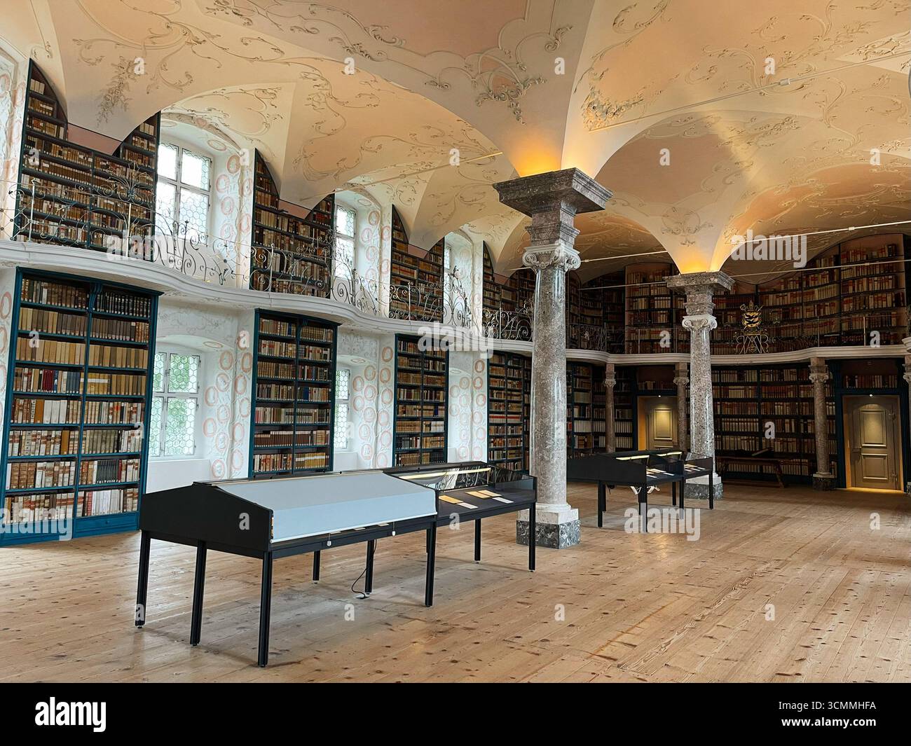 Einsiedeln, Schweiz - 28. September 2022: Elegantes Bibliotheksinnere mit kunstvoller Decke, Bücherregalen und warmem Tageslicht im Kloster Einsiedeln Stockfoto