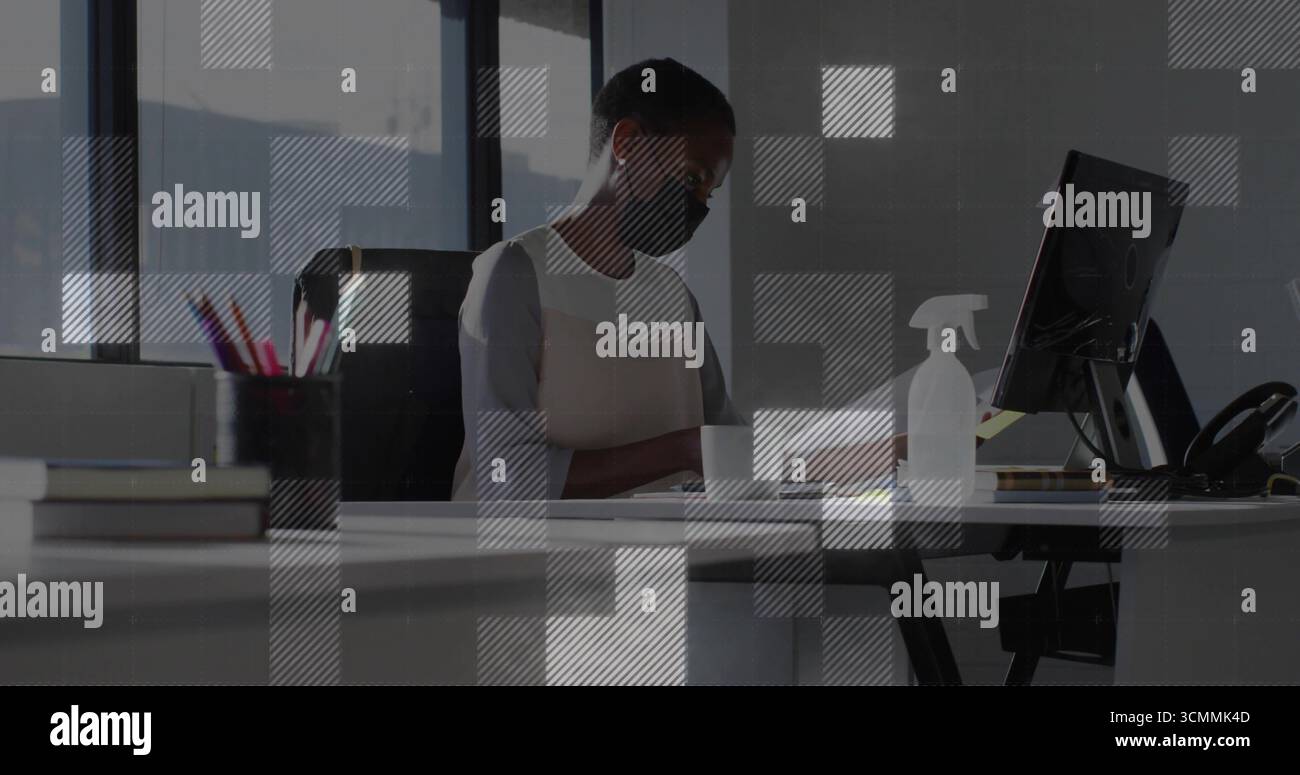 Überprüfen von Dokumenten Frau trägt schwarze Gesichtsmaske am hellen Bürotisch, mit Monitor Sprühflasche Stockfoto