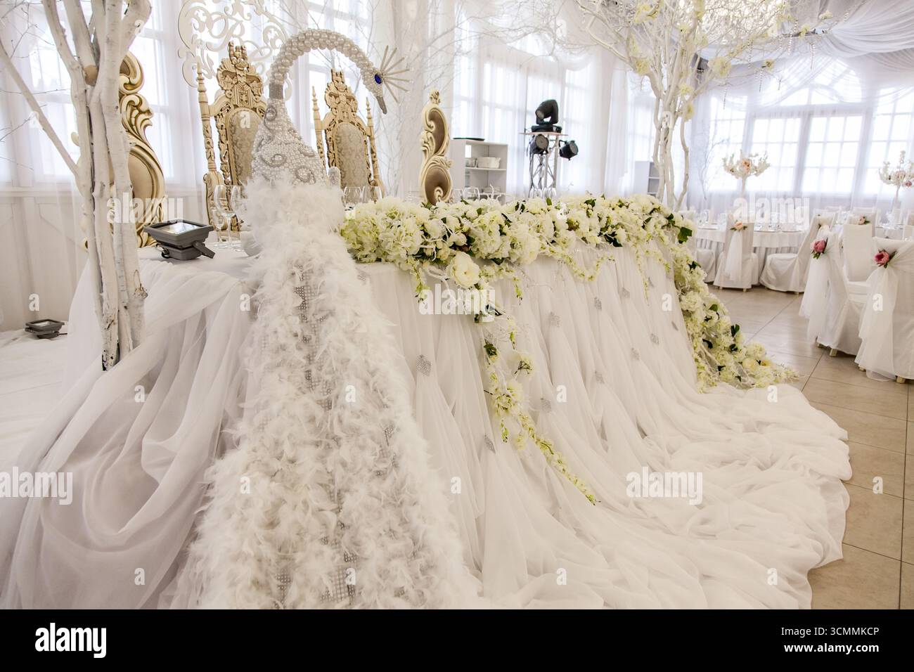 Ein atemberaubendes Set für Hochzeitstisch für Braut und Bräutigam ist mit eleganten Pfauendekorationen versehen. Der Tisch ist mit Federn, Perlen und exquisiten Blumen geschmückt Stockfoto