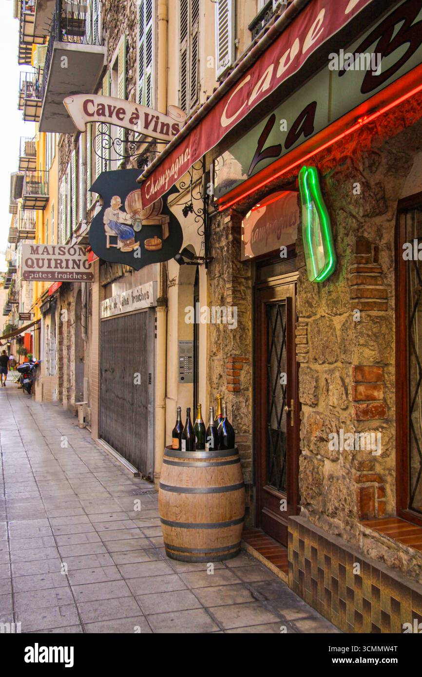 Typisch altes französisches Weingeschäft La Cave a Vins mit Steinmauer und einem Fass und Flaschen draußen auf der Straße. Nizza, Frankreich - 25. september 2021. Stockfoto