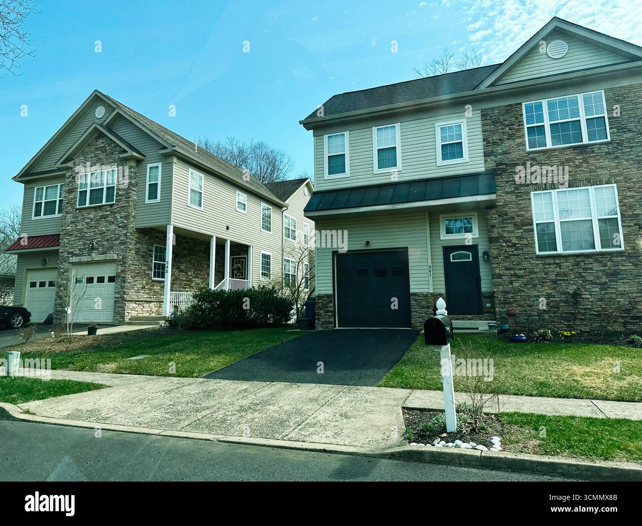 Jenkintown, Pennsylvania, USA - 01. April 2025: Zwei Einfamilienhäuser mit Steindetails und moderner Architektur in New Jersey. Stockfoto