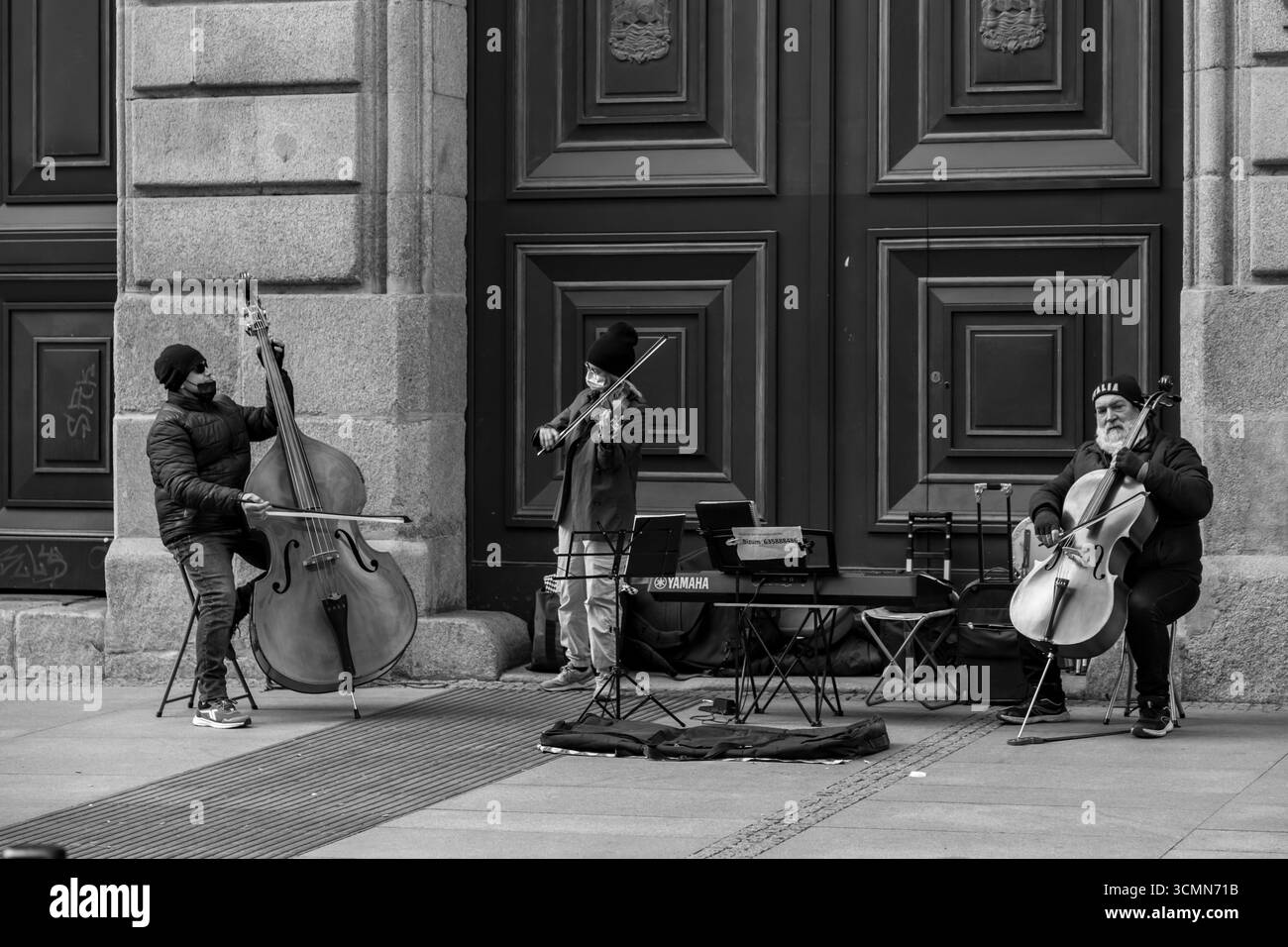Madrid, Spanien - 19. FEBRUAR 2022: Straßenmusiker mit Doppelzelloes und einer Geige in der Calle de Alcala, Madrid. Stockfoto