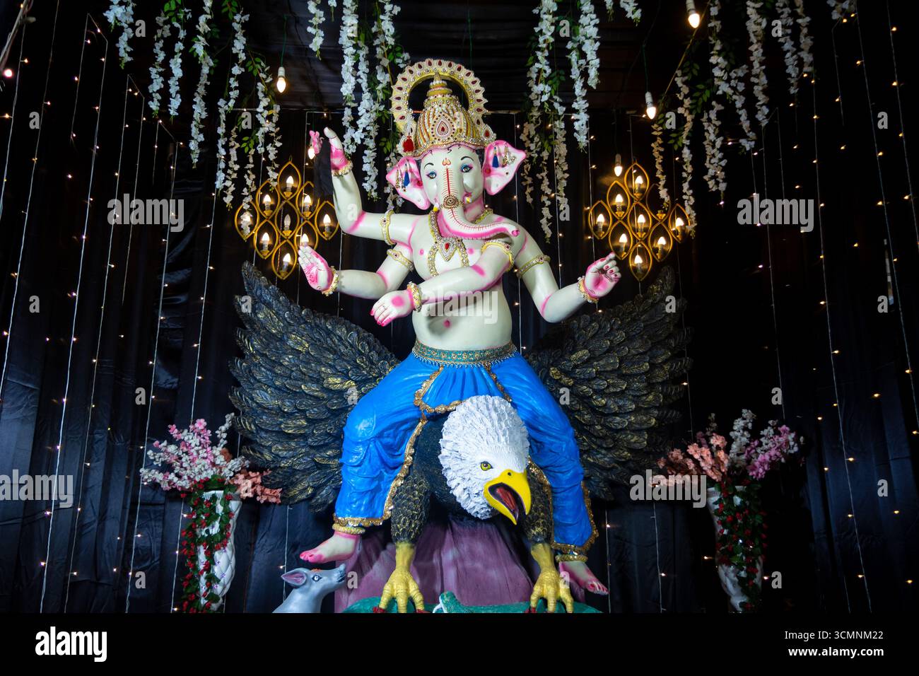 Dekoratives Idol von Lord Ganesha auf Garuda mit festlicher Beleuchtung und Blumendekor Stockfoto