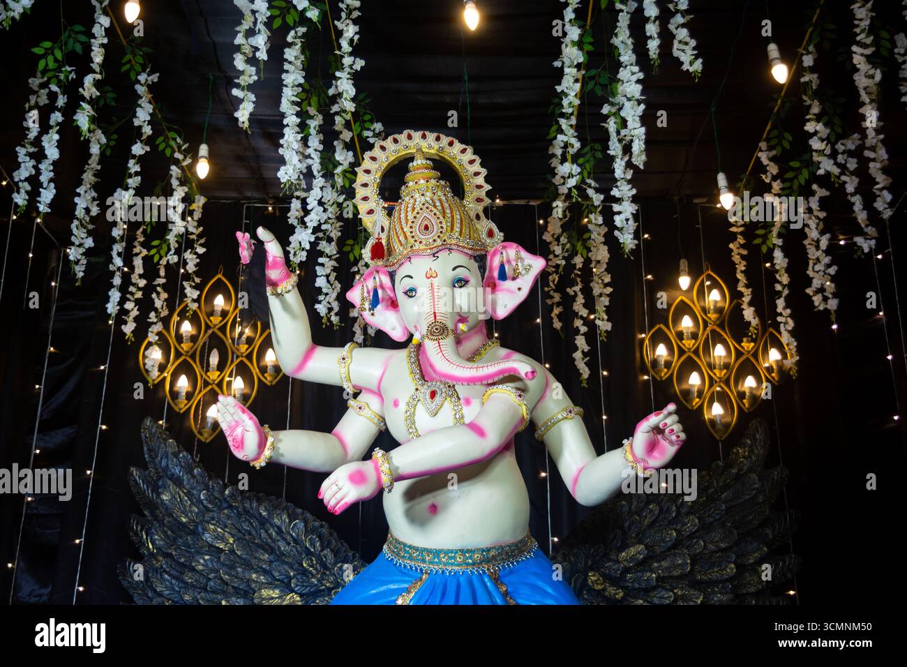 Dekoratives Idol von Lord Ganesha auf Garuda mit festlicher Beleuchtung und Blumendekor Stockfoto
