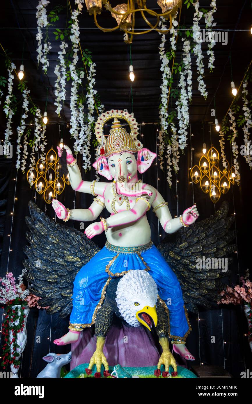 Dekoratives Idol von Lord Ganesha auf Garuda mit festlicher Beleuchtung und Blumendekor Stockfoto