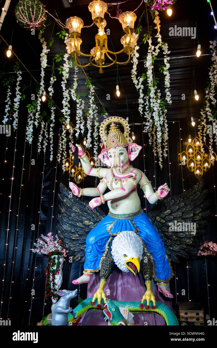 Dekoratives Idol von Lord Ganesha auf Garuda mit festlicher Beleuchtung und Blumendekor Stockfoto