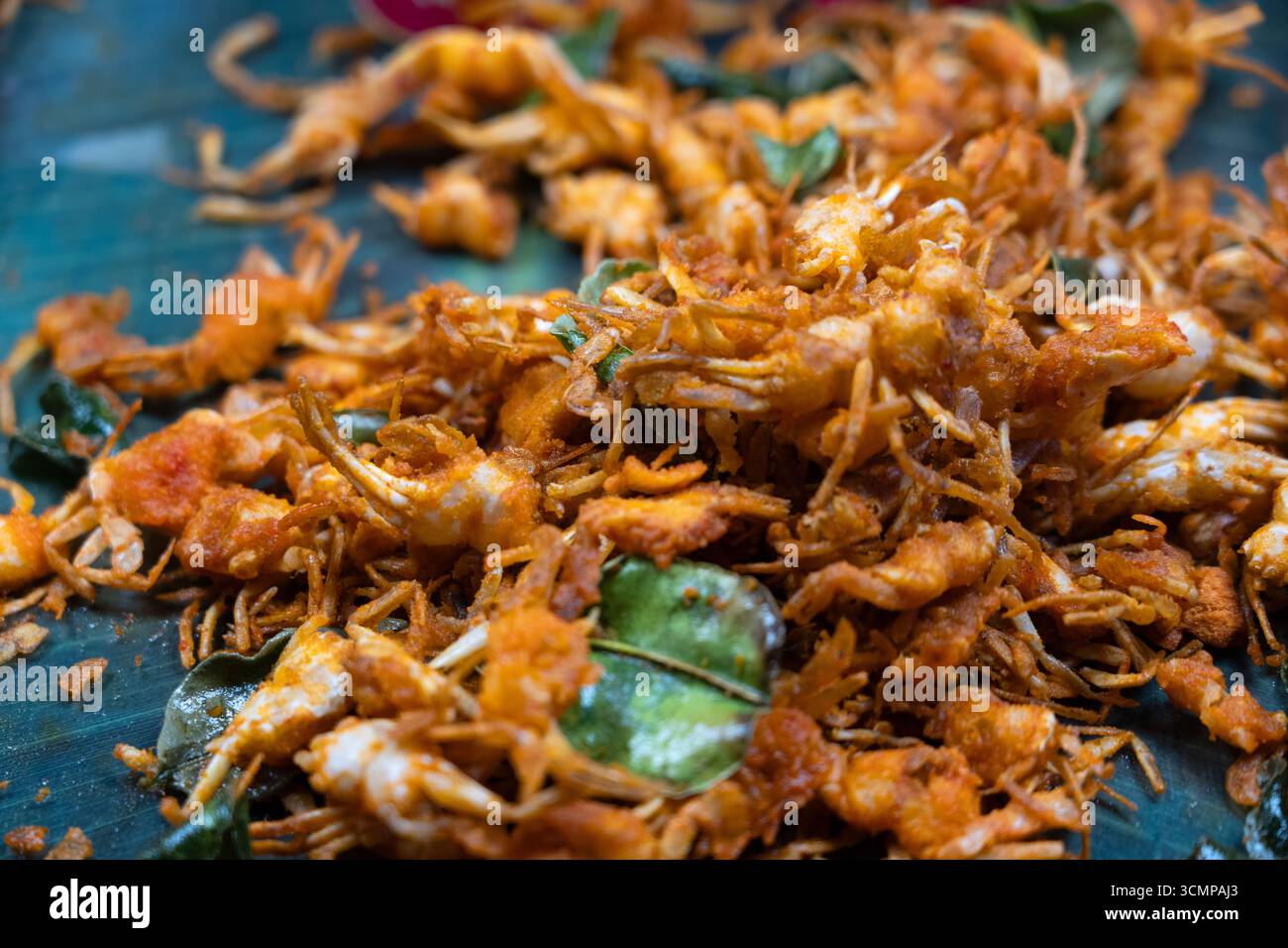 Nahaufnahme knuspriger, frittierter Babykrabben mit Curryblättern, goldbraun und knusprig, ein beliebter asiatischer Snack und Delikatesse. Stockfoto