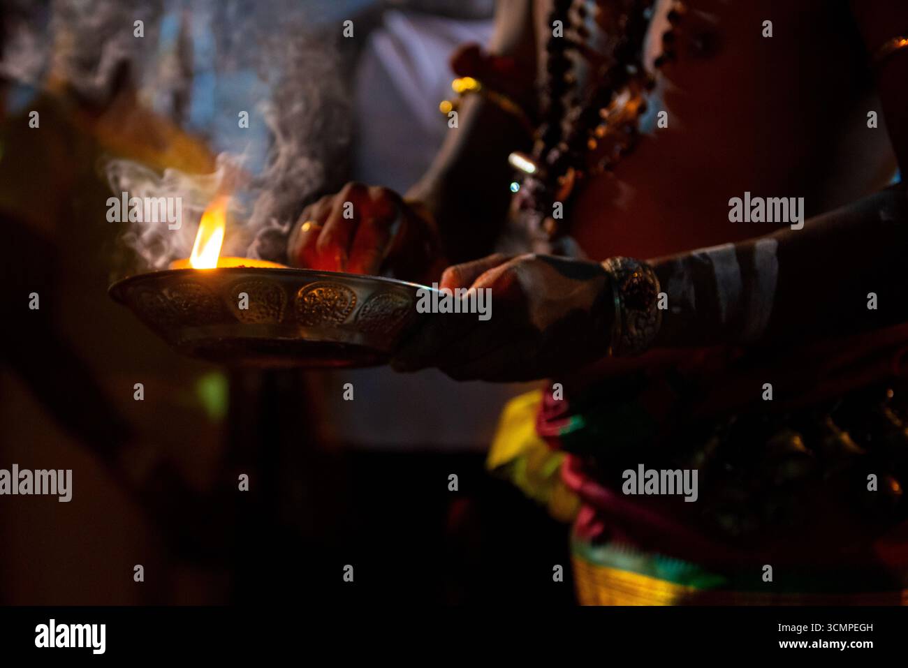 Geweihter, der während des Thaipusam-Festivalrituals Weihrauch hält, wobei Rauch in der Luft aufsteigt Stockfoto