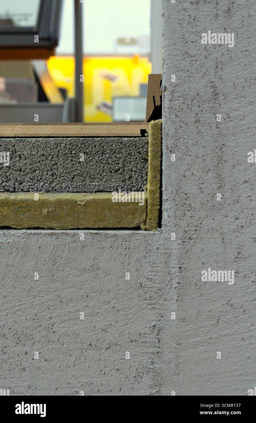 Eine Schnittansicht zeigt den Querschnitt einer Wand und zeigt Schichtbaumaterialien: Eine äußere Stuckoberfläche, einen grauen porösen Block und eine Schicht Gelb Stockfoto