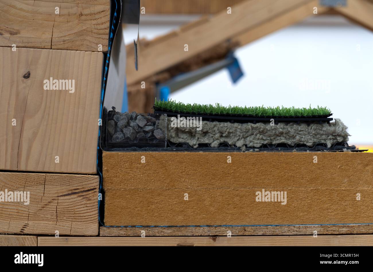 Dieses mehrschichtige Dachsystem kombiniert Dämmung, Abfluss und Grün. Es besteht aus Holz, starren Brettern, Mineralwolle, Kies und anderem Stockfoto