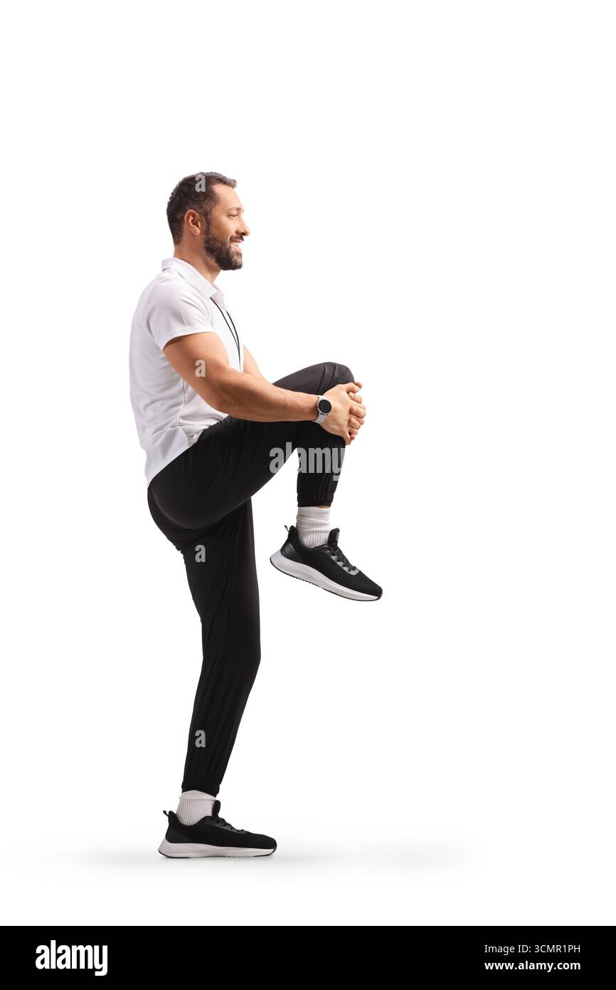 Profilaufnahme eines Mannes, der das Knie streckt, isoliert auf weißem Hintergrund Stockfoto