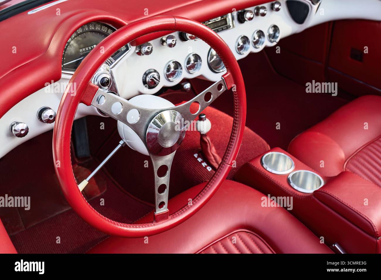Innenraum des Sportwagens in Vintage-Rot mit poliertem Armaturenbrett und Lenkraddesign Stockfoto