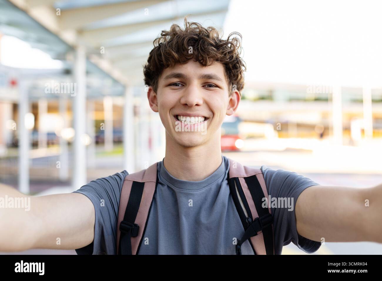 Porträt eines jungen gutaussehenden Mannes, der Selfie am Flughafenterminal mit Rucksack macht Stockfoto