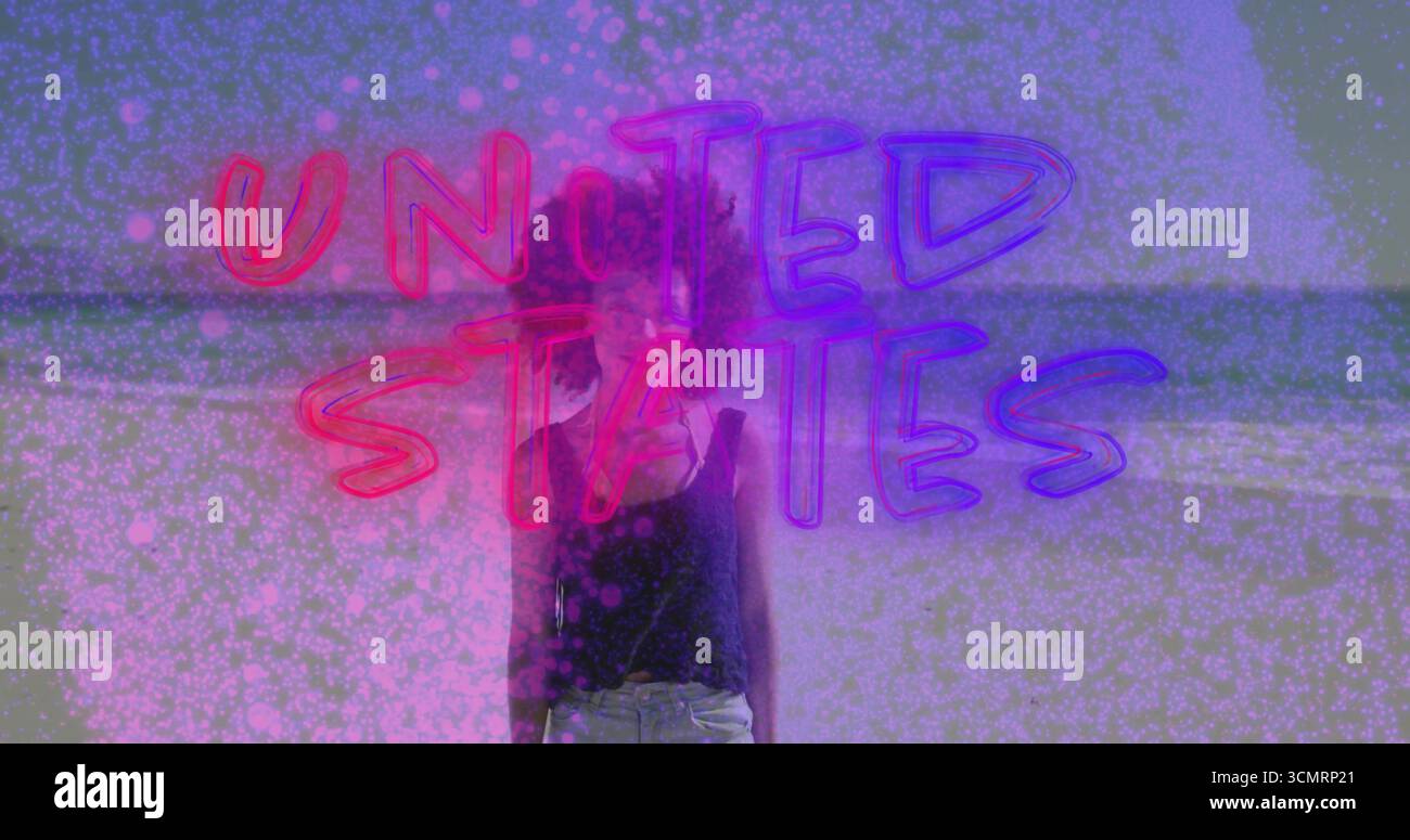 Stehende Frau trägt ein schwarzes Oberteil am Strand, mit Neontexten, die die USA lesen, rosa Punkte überlagert Stockfoto