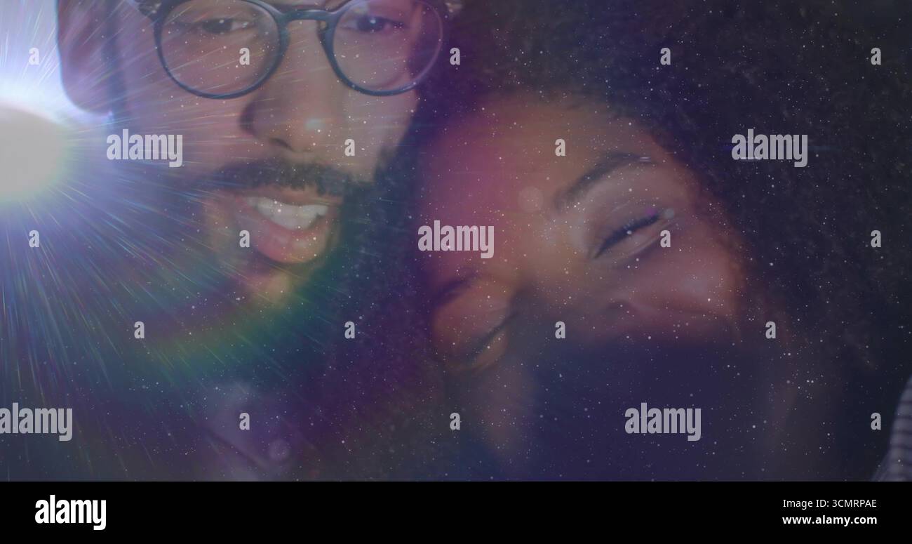 Lächelndes Paar, das sich bei schlechten Lichtverhältnissen nahe lehnt, mit einer runden Brille Stockfoto