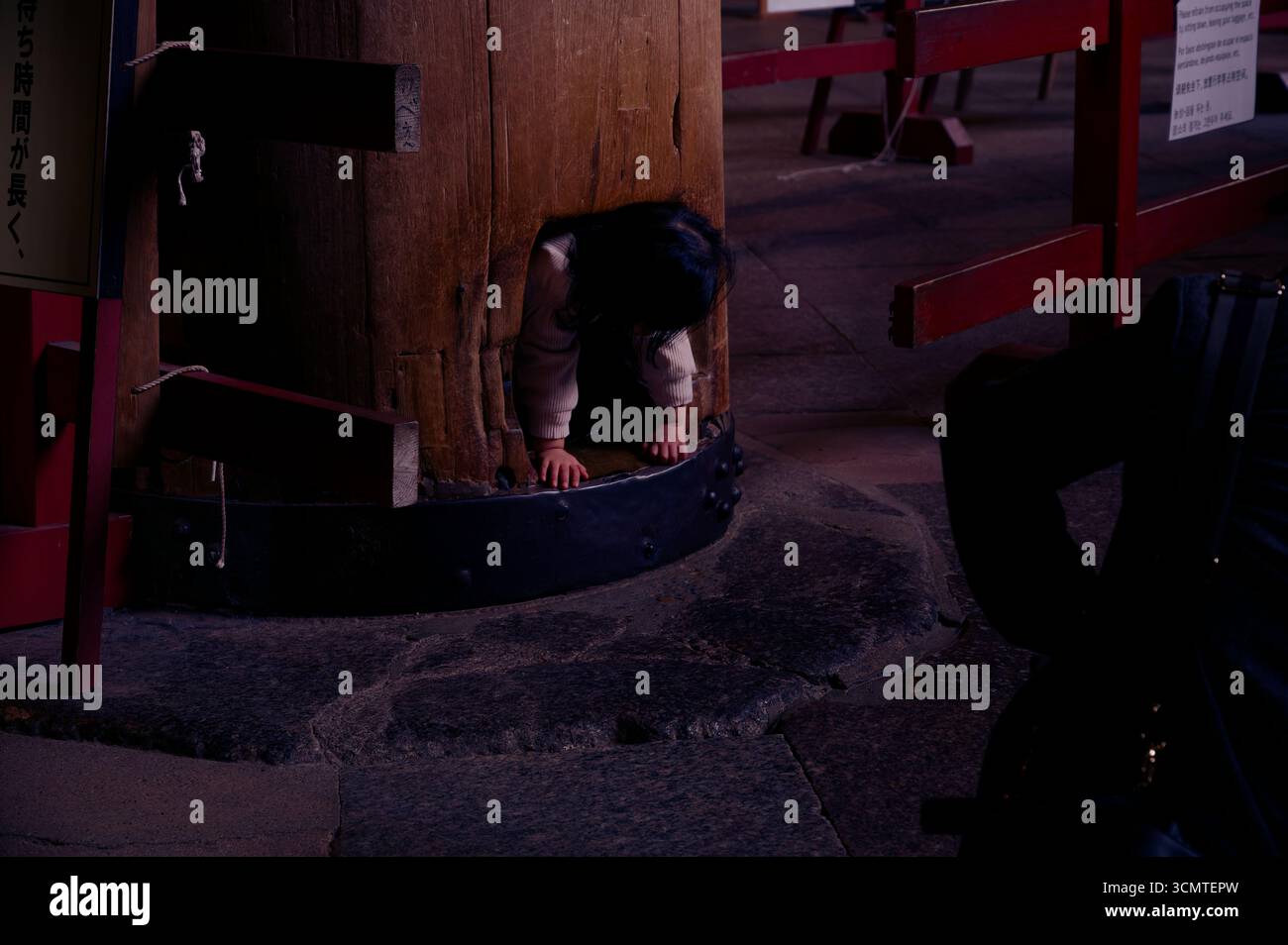 Kid kriecht durch das Nasenloch am Fuß der „Weisheitssäule“ in der Buddha-Halle von Tōdai-JI und hofft auf Segnungen im nächsten Leben Stockfoto