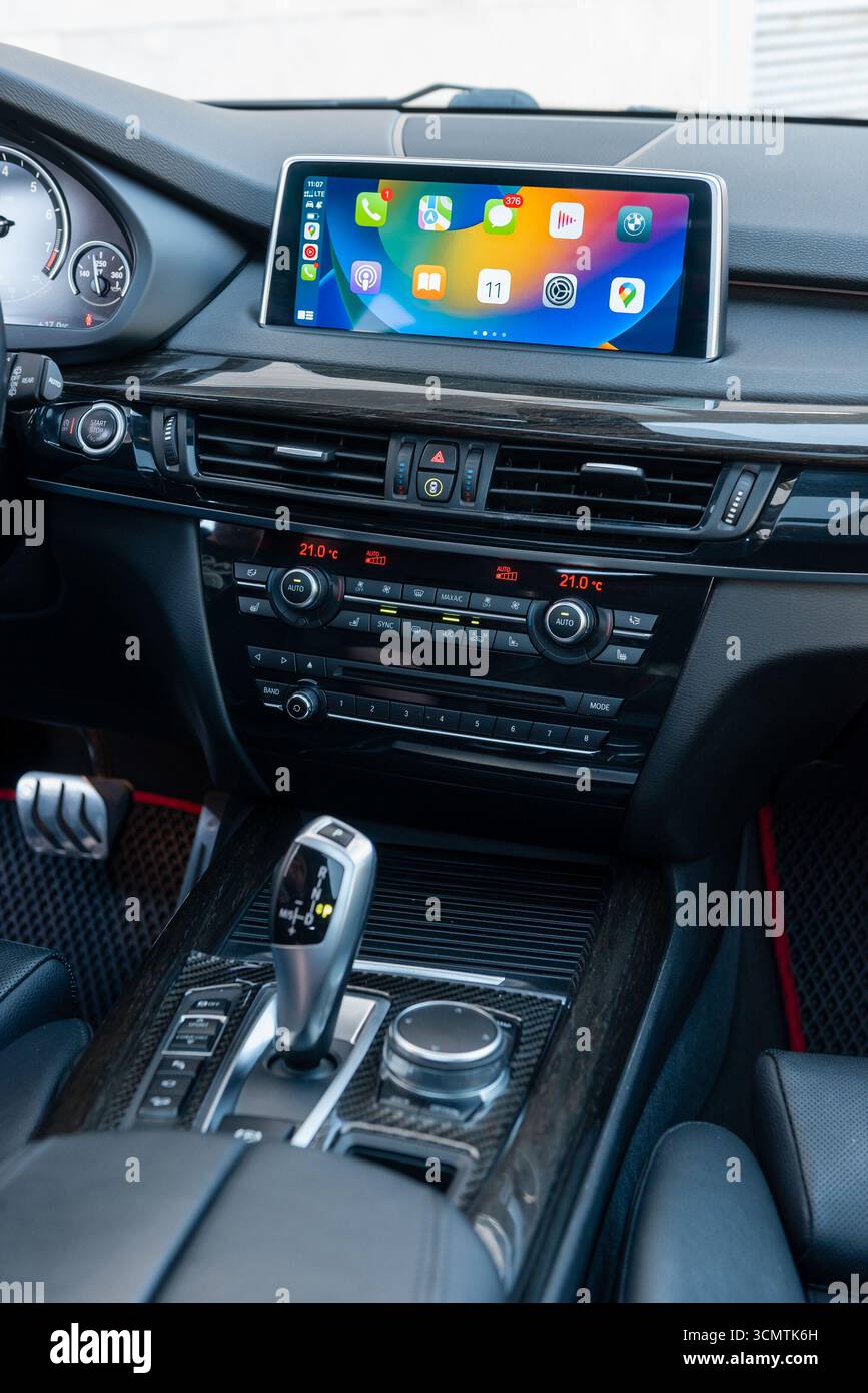 BMW Mittelkonsole innen. Zentraler Teil der Fahrzeugfront: Mittelkonsole mit Gangschaltung, Armaturenbrett, Apple carplay Hauptmenü auf dem oberen Bildschirm. Stockfoto