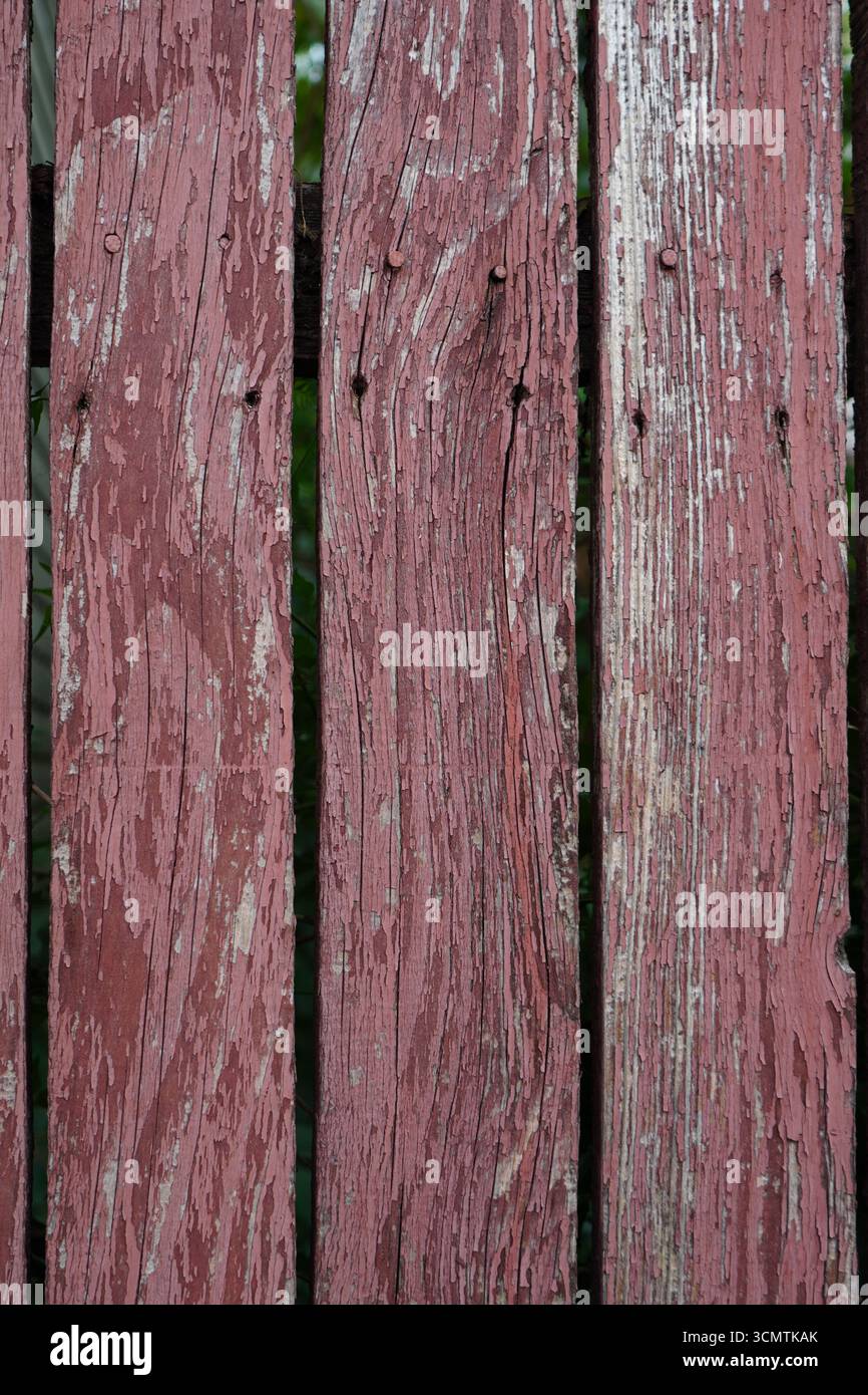 Nahaufnahme von bemalten verwitterten Holzdielen aus altem Zaunhintergrund Stockfoto