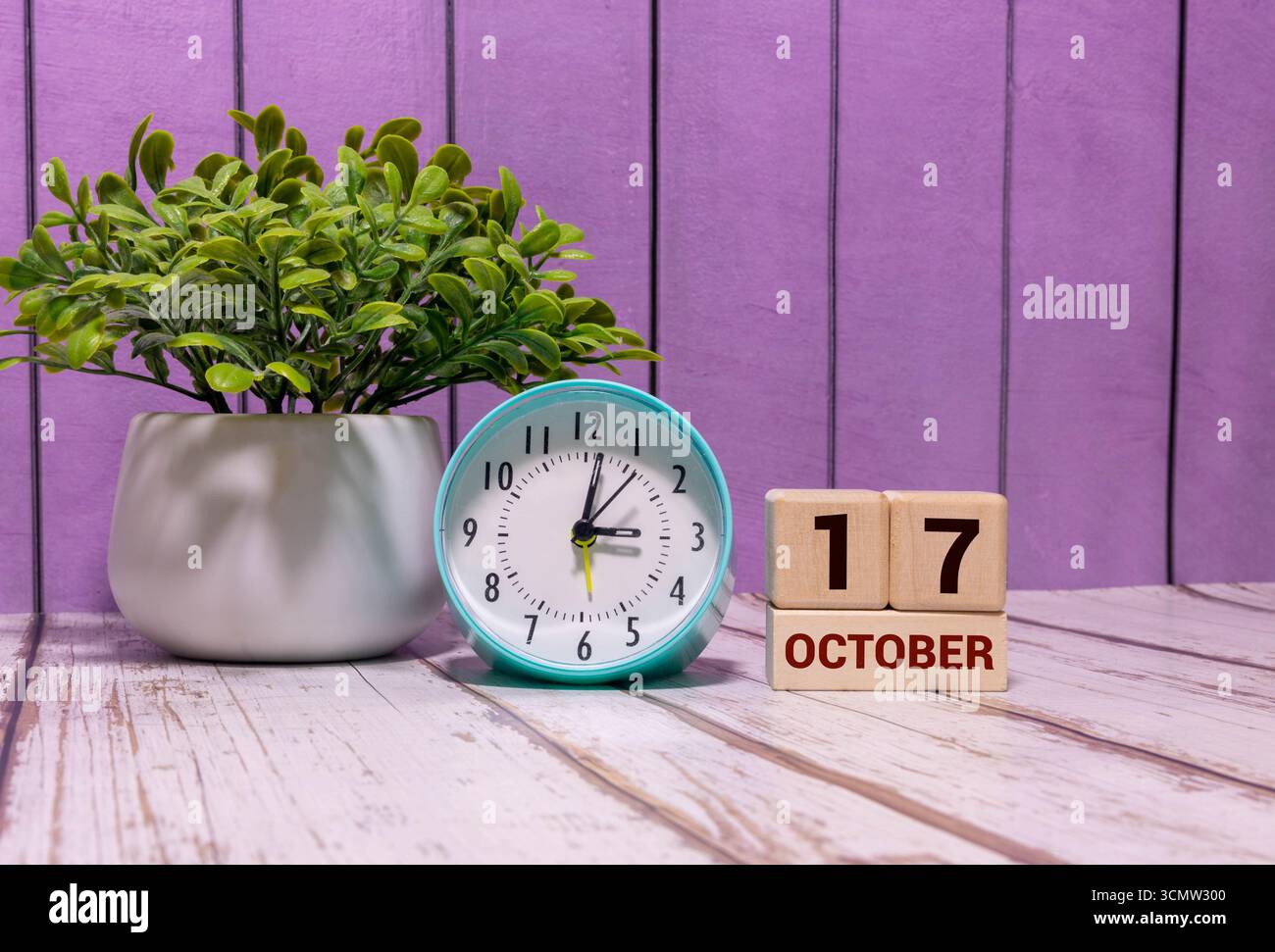 Holzkalender mit Datum 17. Oktober. Monatskalender für Planung und Management-Konzept mit Wecker auf hölzernem Hintergrund Stockfoto