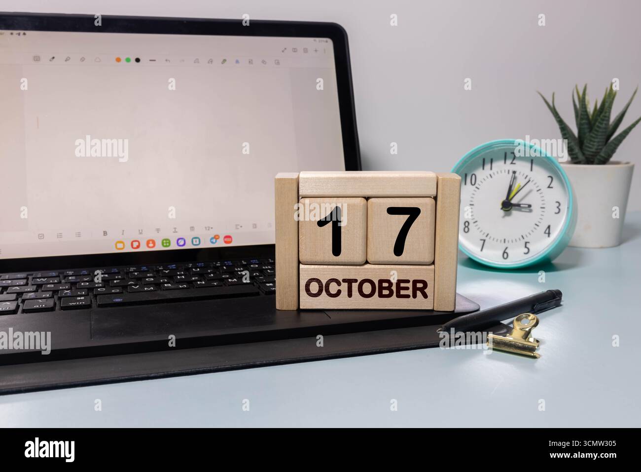 Holzkalender mit Datum 17. Oktober. Monatskalender für Planung und Management-Konzept mit Wecker auf hölzernem Hintergrund Stockfoto