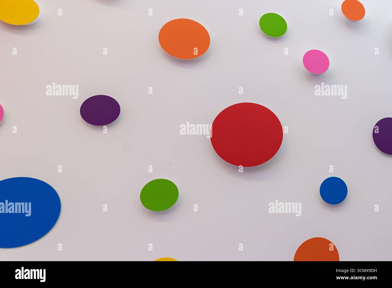 Abstrakte bunte Kreise auf weißem Hintergrund. Minimalistisches geometrisches Muster, perfekt für Design, Dekoration, kreative Projekte, Partys oder Moderne Stockfoto