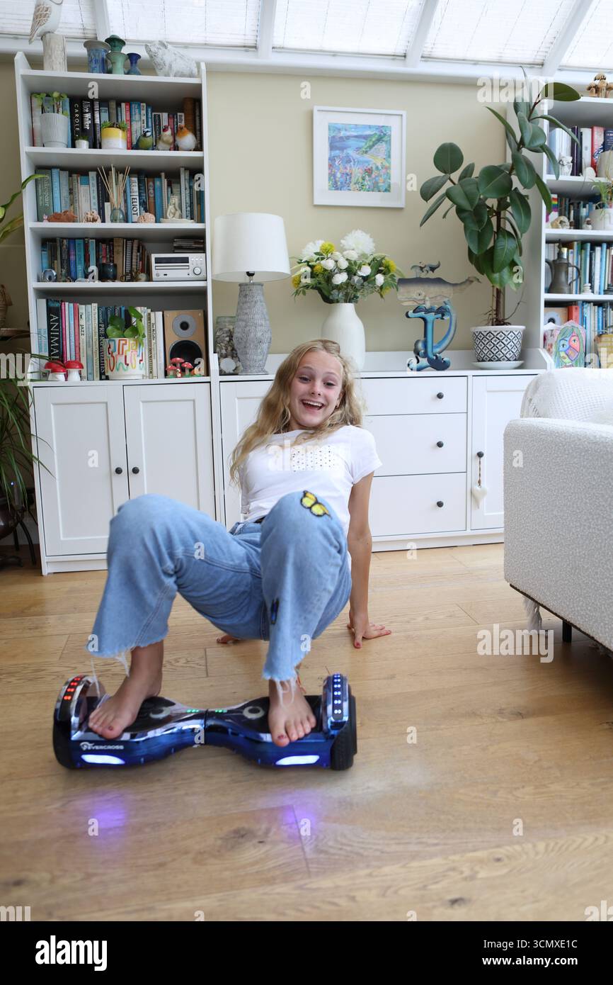 Mädchen auf Hoverboard-Tech-Spielzeug drinnen Stockfoto
