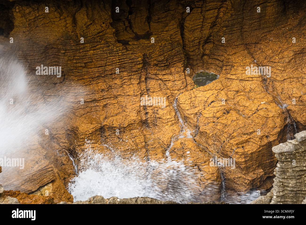 Mächtige Seebrücke durch Blowhole in Honey-Colour Rock bei Pancake Rocks, Punakaiki, Westküste, Neuseeland Stockfoto