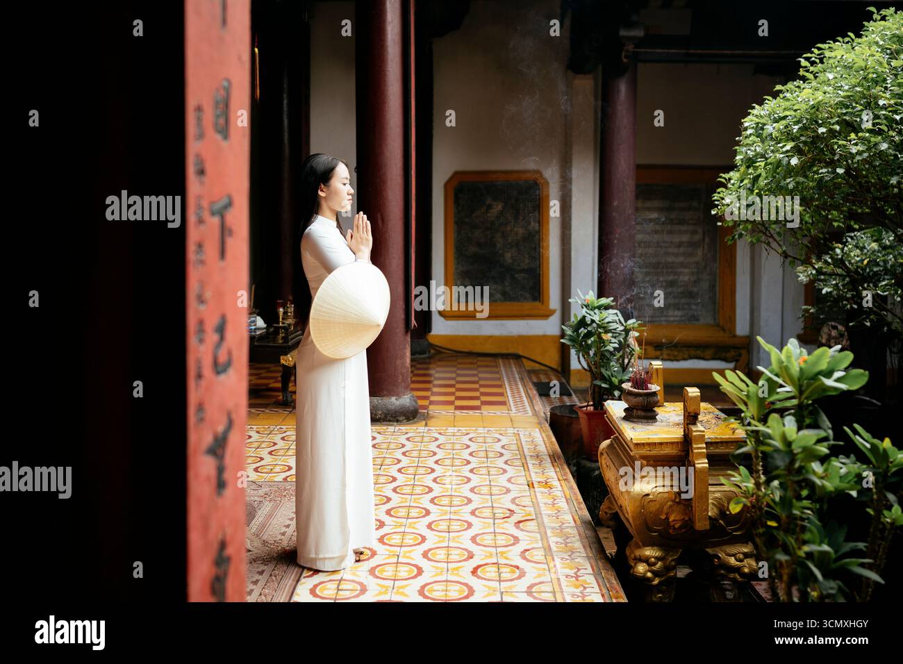 Vietnamesische Frau in ao dai im Quang Cong Tempel, Hoi an, Provinz Quang Nam, Vietnam Stockfoto